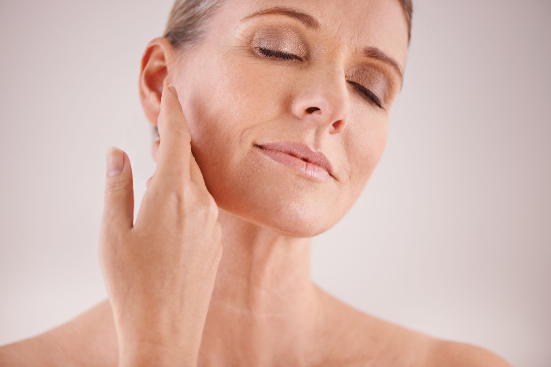 woman aging gracefully with hand to her face